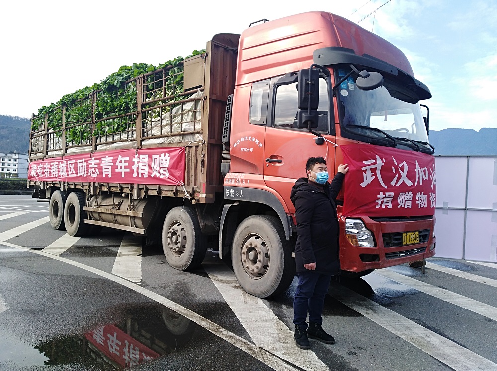 图一：2月9日，赵伟登车前往武汉捐赠蔬菜前与自己的货车合影留念。.jpg