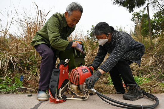 志愿者正在双桥镇豆芽村为割草机添加燃油.jpg